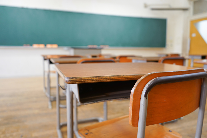 School classroom desk with blackboard